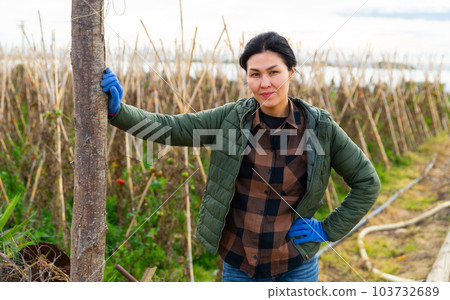 Portrait of positive female farmer on background of pea plantation on farm field Portrait of positive female farmer on background of pea plantation on farm field 103732689
