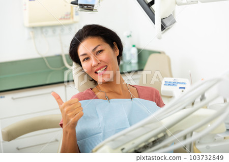 Happy asian woman sitting in dental chair 103732849