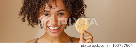 Young woman holding cosmetic sponge in studio 103737604