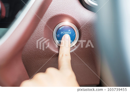Finger press a car ignition button or START engine inside modern electric automobile. Keyless, change, strategy, vision, innovation and future concept 103739455