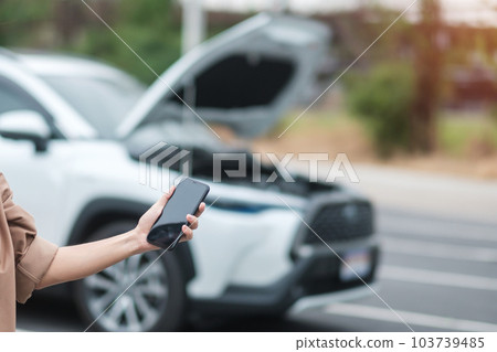 woman driver using mobile phone during problem car. Breakdown or broken car on road. Vehicle Insurance, maintenance and service concept woman driver using mobile phone during problem car. Breakdown or broken car on road. Vehicle Insurance, maintenance and service concept 103739485