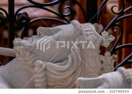 Stone carved statues of royalty lying in state in close up photo showing primitive crown, bearded face of medieval king. High quality photo Stone carved statues of royalty lying in state in close up photo showing primitive crown, bearded face of medieval king. High quality photo 103740054