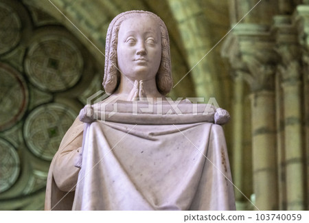 Close up of marble statue of Anne of Bretagne, early queen of France in an attitude of prayer. Fine details of hair, draped cloth. High quality photo 103740059