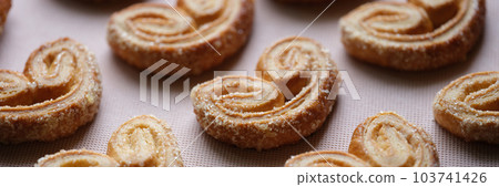 Delicious puff pastry cookies with sugar sprinkles Delicious puff pastry cookies with sugar sprinkles 103741426