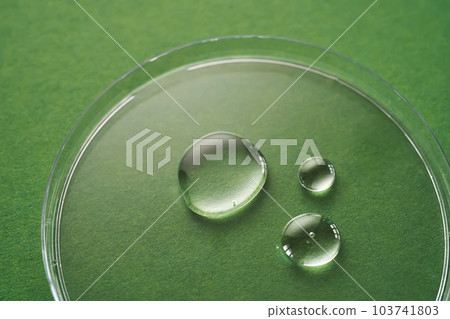 Three drops of liquid on a green background. 103741803