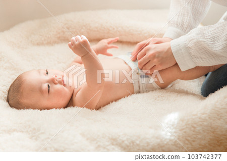 Mom, parent and child, mother and child exchanging baby diapers Mom, parent and child, mother and child exchanging baby diapers 103742377