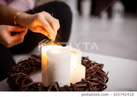 A girl from the fire of a candle standing on a table lights fireworks. A girl from the fire of a candle standing on a table lights fireworks. 103742418
