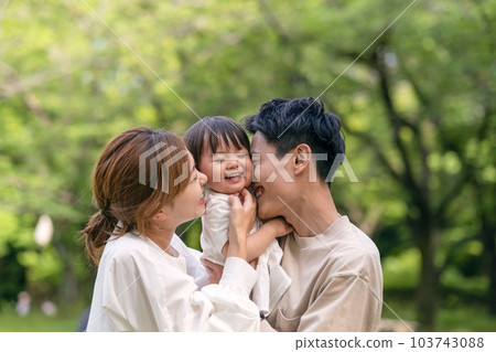 Portrait of a laughing family in a fresh green park 103743088