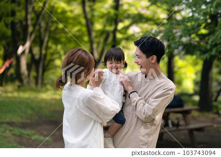 A family laughing in a fresh green park 103743094