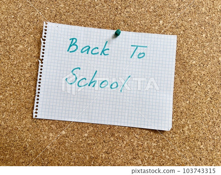 Back to school hand written text on notepad paper sheet and pinned on cork board 103743315