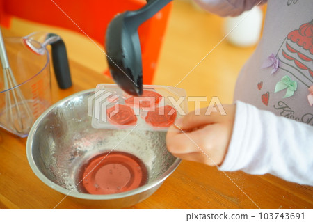 A child in the third grade of elementary school is making gummy bears. Where it is poured into the mold. A child in the third grade of elementary school is making gummy bears. Where it is poured into the mold. 103743691
