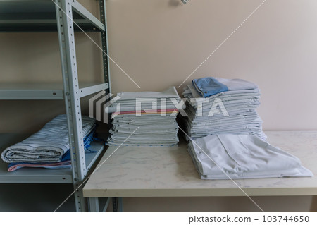 Linens piled neatly on shelves. There are folded bed sheets, towels, wash clothes 103744650