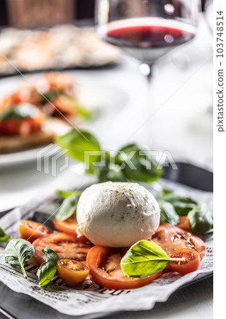 Italian light summer Caprese salad with shole buffalo mozzarella, cherry and sliced tomatoes and fresh basil Italian light summer Caprese salad with shole buffalo mozzarella, cherry and sliced tomatoes and fresh basil 103748514