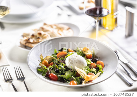 Buffalo mozzerala ball as a centerpiece of a salad with rocket, leaves, cherry tomatoes, physalis and olive oil Buffalo mozzerala ball as a centerpiece of a salad with rocket, leaves, cherry tomatoes, physalis and olive oil 103748527