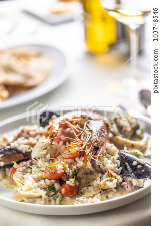 Detail of a seafood risotto made the Italian way and served on a shallow plate Detail of a seafood risotto made the Italian way and served on a shallow plate 103748546