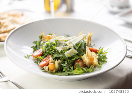 Ruccola salad with cherry tomatoes, physalis and parmesan cheese shavings Ruccola salad with cherry tomatoes, physalis and parmesan cheese shavings 103748553