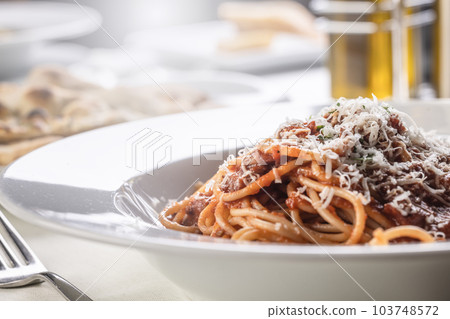 Detail of spaghetti with tomato sauce, basil, and parmesan on top 103748572