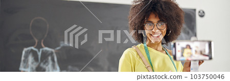 African-American tutor of clothes design course shows color pale 103750046