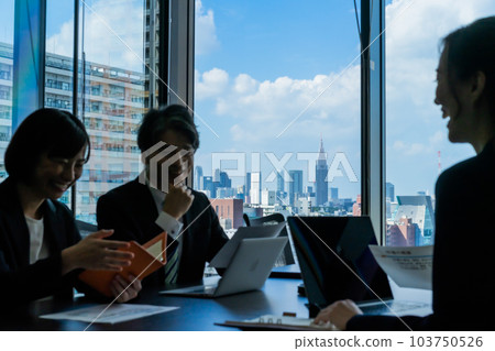 Silhouettes of men and women having a meeting in a conference room Silhouettes of men and women having a meeting in a conference room 103750526