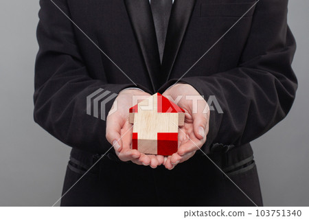 Danish person holding wooden house with flag of Denmark Finance, investment, mortgage 103751340