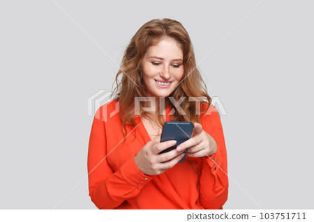 Happy smiling woman using smartphone, studio portrait Happy smiling woman using smartphone, studio portrait 103751711