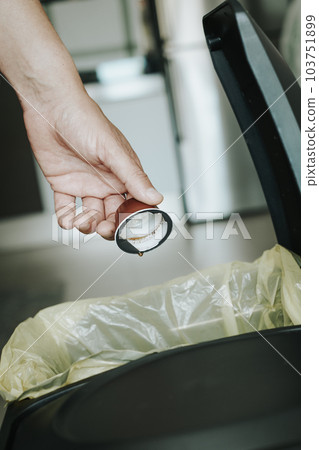 man throwing a coffee capsule to the dustbin 103751899