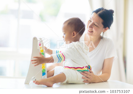 Baby boy playing with wooden abacus. Baby boy playing with wooden abacus. 103753107