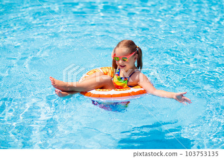 Child in swimming pool on toy ring. Kids swim. 103753135