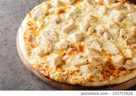 Hot cheese Alfredo pizza with chicken close-up on a wooden board. Horizontal 103753626