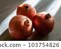 Three fresh ripe pomegranates on a gray wooden table 103754826
