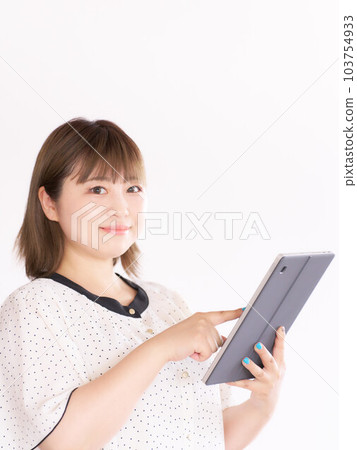 A young woman holding a tablet and looking at her business casual 103754933