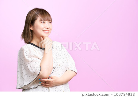 年輕女子一邊望著遠方，一邊摸著下巴 商務休閒裝 103754938