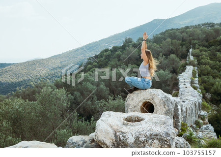 Woman relax in yoga pose at ruins of Delikkemer aqueduct 103755157