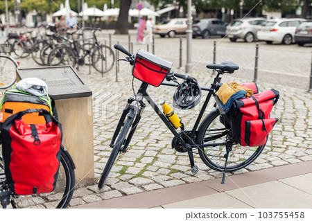 Many modern bicycles with travel luggage bags equipment parked in old european city center street. Healthy eco sustainable tourism family trip lifestyle. Bike hobby adventure tour journey Many modern bicycles with travel luggage bags equipment parked in old european city center street. Healthy eco sustainable tourism family trip lifestyle. Bike hobby adventure tour journey 103755458