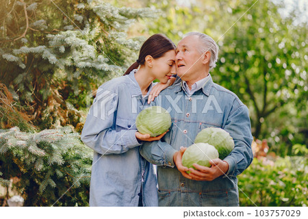 Senior with green gabbage. Brunette in a blue shirt. Grandfather with grandaughter. 103757029