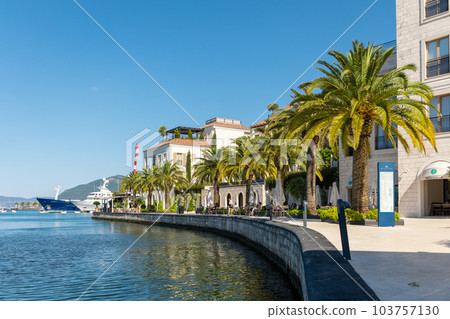 Sea and summer vacation. View of coastal buildings with palm trees on seashore. Copy space. Mediterranean style architecture Sea and summer vacation. View of coastal buildings with palm trees on seashore. Copy space. Mediterranean style architecture 103757130