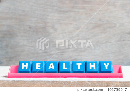Tile alphabet letter with word healthy in red color rack on wood background 103759947