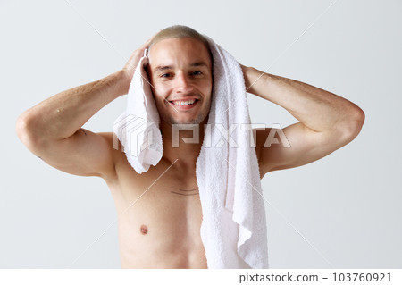 Morning shower routine. Handsome young shirtless man washing body and face against white studio background Morning shower routine. Handsome young shirtless man washing body and face against white studio background 103760921