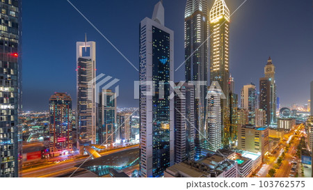 Aerial view of Dubai International Financial District with many skyscrapers day to night timelapse. Aerial view of Dubai International Financial District with many skyscrapers day to night timelapse. 103762575