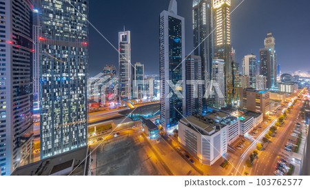 Aerial view of Dubai International Financial District with many skyscrapers day to night timelapse. 103762577