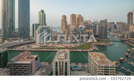 Panorama showing Dubai Marina with several boat and yachts parked in harbor and skyscrapers around canal aerial timelapse. Panorama showing Dubai Marina with several boat and yachts parked in harbor and skyscrapers around canal aerial timelapse. 103762726