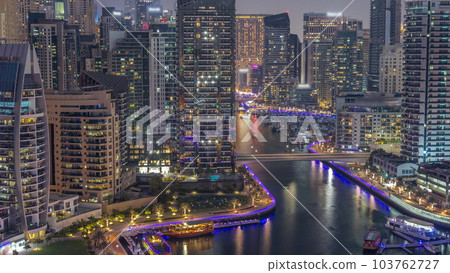 Dubai Marina with several boat and yachts parked in harbor and skyscrapers around canal aerial day to night timelapse. Dubai Marina with several boat and yachts parked in harbor and skyscrapers around canal aerial day to night timelapse. 103762727