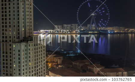 Bluewaters island with modern architecture and ferris wheel aerial night timelapse. Bluewaters island with modern architecture and ferris wheel aerial night timelapse. 103762765