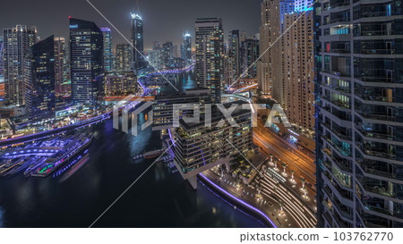Aerial view to Dubai marina skyscrapers around canal with floating boats night timelapse 103762770
