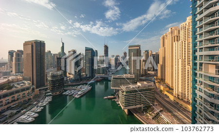 Aerial view to Dubai marina skyscrapers around canal with floating boats timelapse Aerial view to Dubai marina skyscrapers around canal with floating boats timelapse 103762773