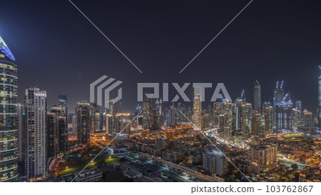 Panorama showing Dubai's business bay towers aerial night timelapse. Rooftop view of some skyscrapers Panorama showing Dubai's business bay towers aerial night timelapse. Rooftop view of some skyscrapers 103762867