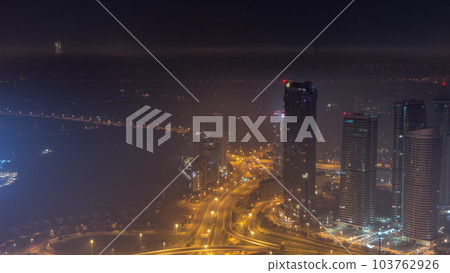 Big crossroad junction between JLT district and Dubai Marina intersected by Sheikh Zayed Road aerial all night timelapse. 103762926