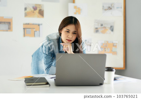 Woman architect reading data on laptop and thinking about new pr Woman architect reading data on laptop and thinking about new pr 103765021