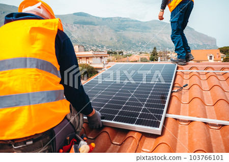 Workers assemble energy system with solar panel for electricity and hot water 103766101
