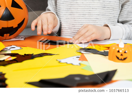Preschool child creates Halloween origami paper bat crafts, close-up hands Preschool child creates Halloween origami paper bat crafts, close-up hands 103766513